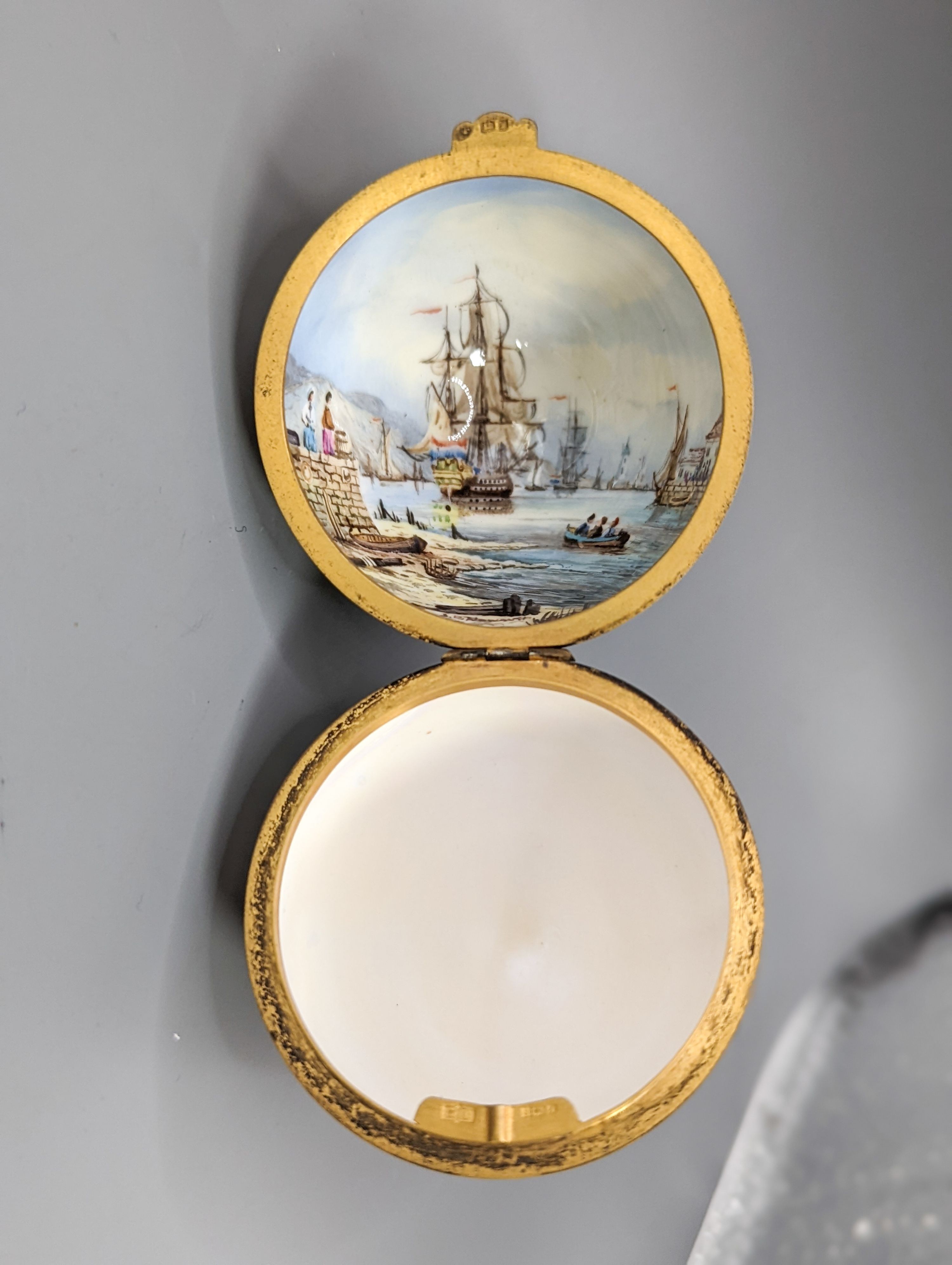 Two silver gilt mounted enamelled eggs with interior seascapes, on silver gilt stands, Birmingham, 1985 & 7 and a smaller similar gilt metal mounted zodiac egg, tallest 8.5cm